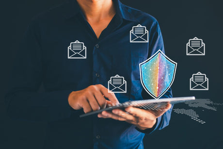 Person using a laptop with security icons and a shield graphic on a dark background